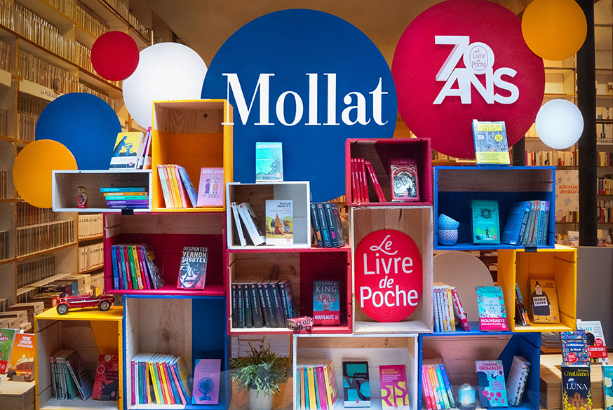 Livre de poche - Mise en scène mécanique bleue entourée de piles de livres