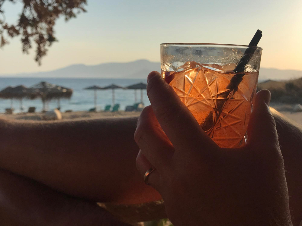 Cocktail au bord de mer, coucher de soleil, verre à la main