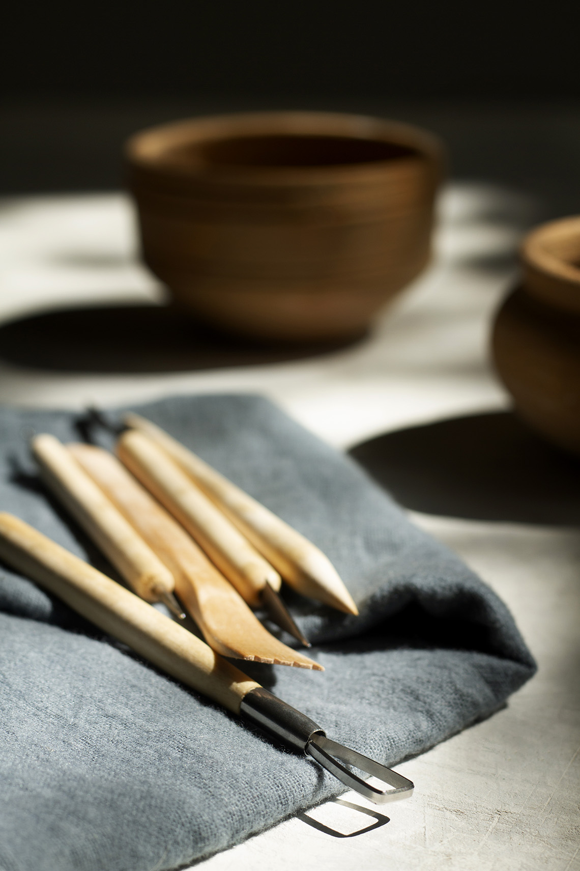 Outils de potier - mirettes et pinceaux posés près de bols