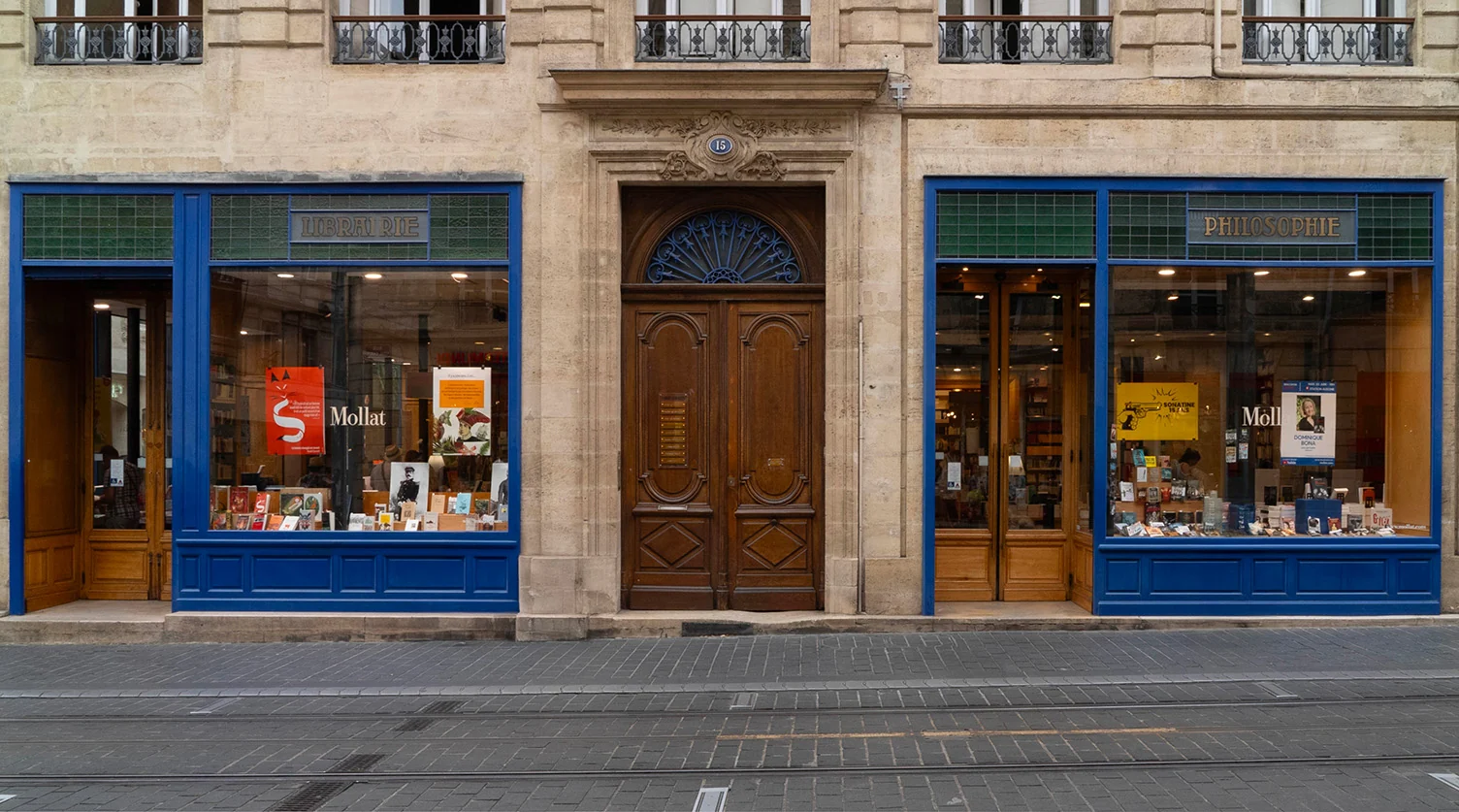 Façade de la Librairie Mollat à Bordeaux avec vitrines bleues et porte bois